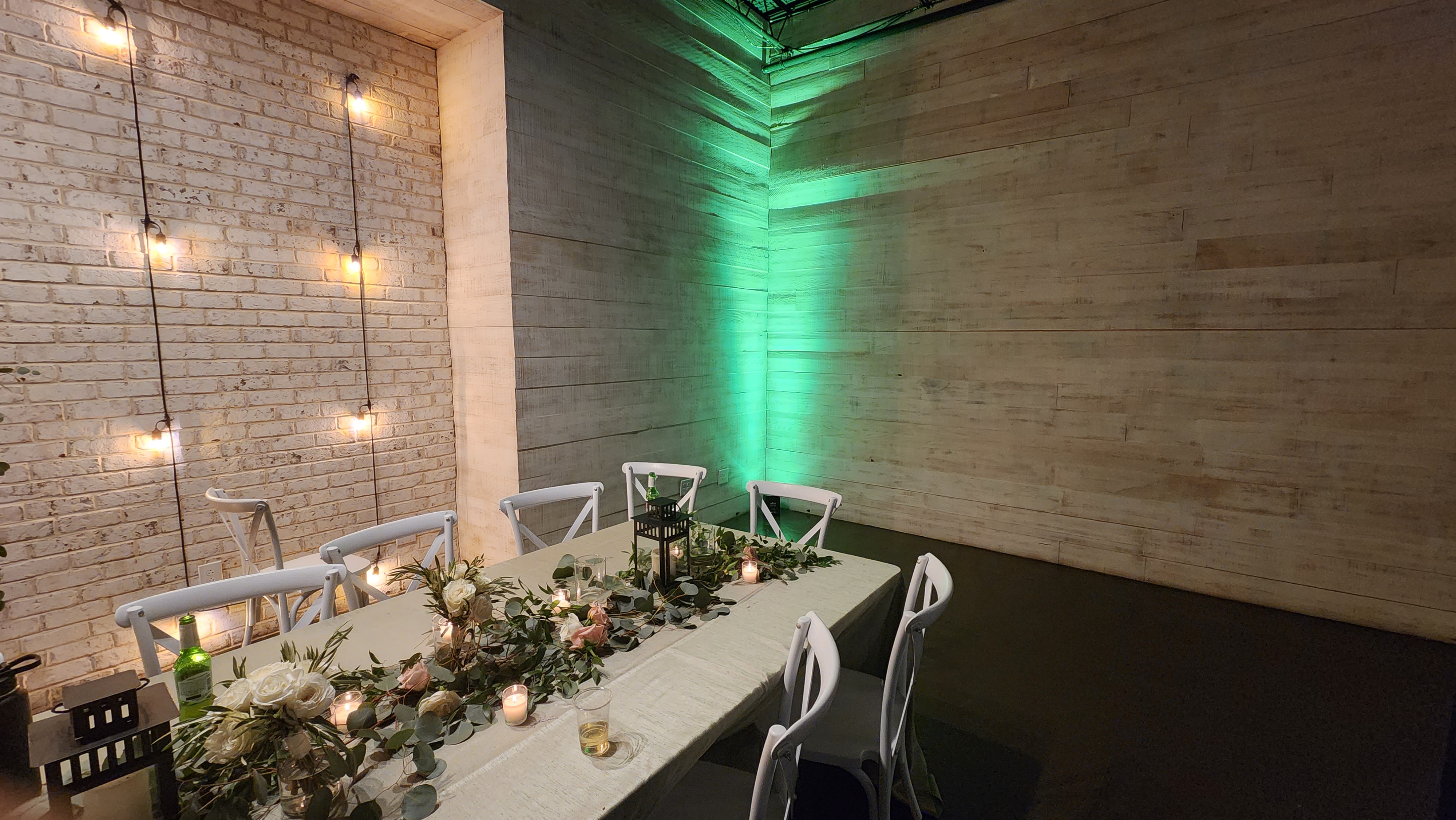 An intimate wedding reception table with warm and green accent lighting